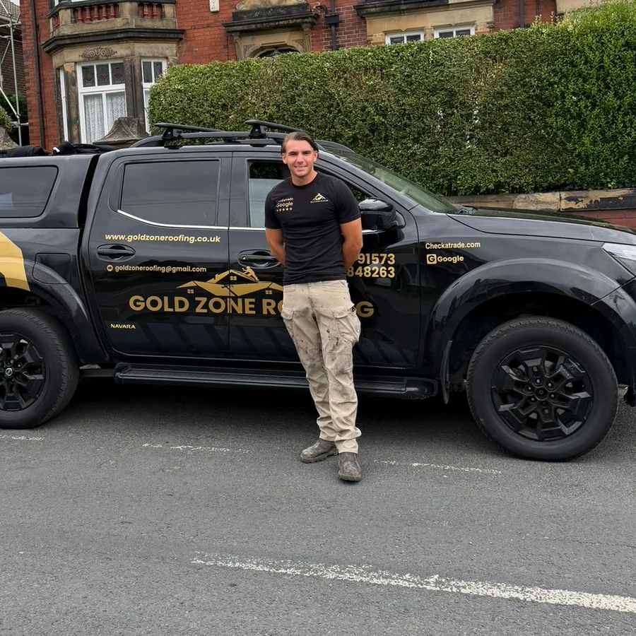 Rudy Ayres, owner of Gold Zone Roofing, next to the company van