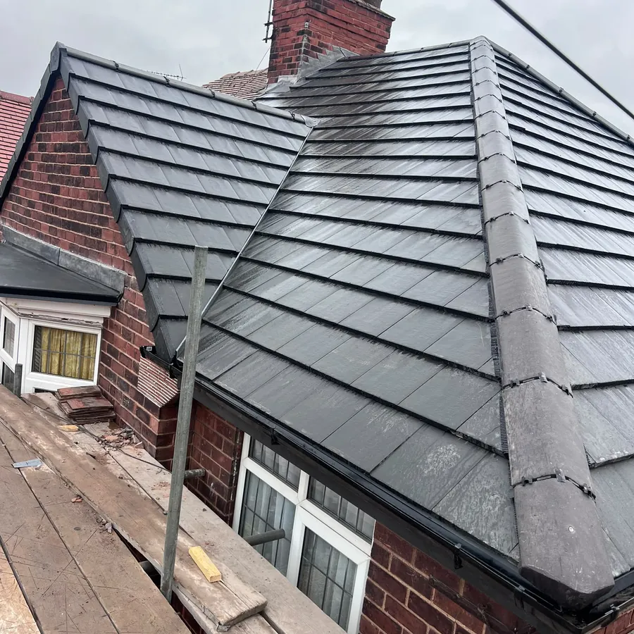 Hipped roof re-covered in grey tiles beside the chimney